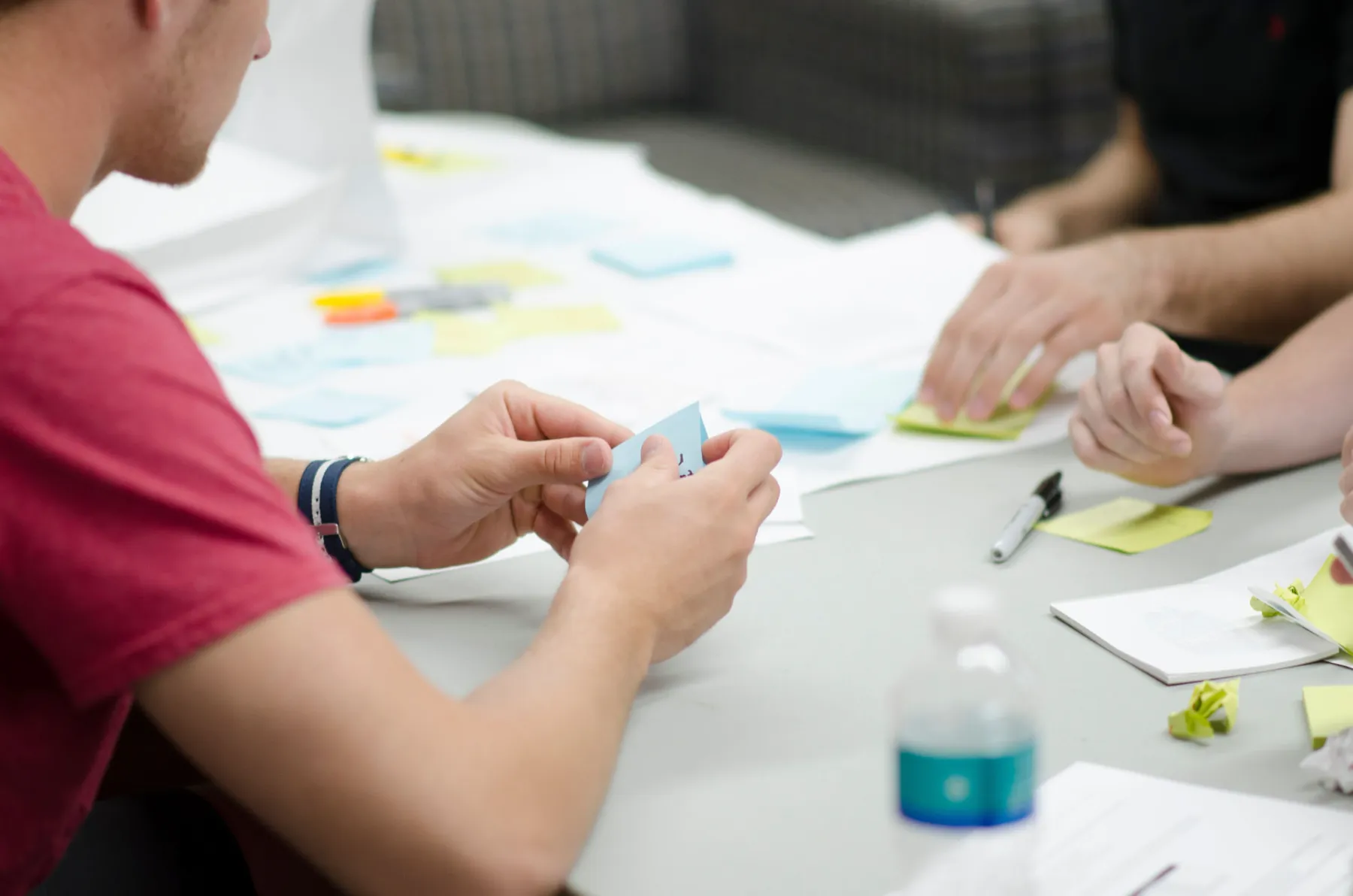 A small group working with sticky notes and paper around a table