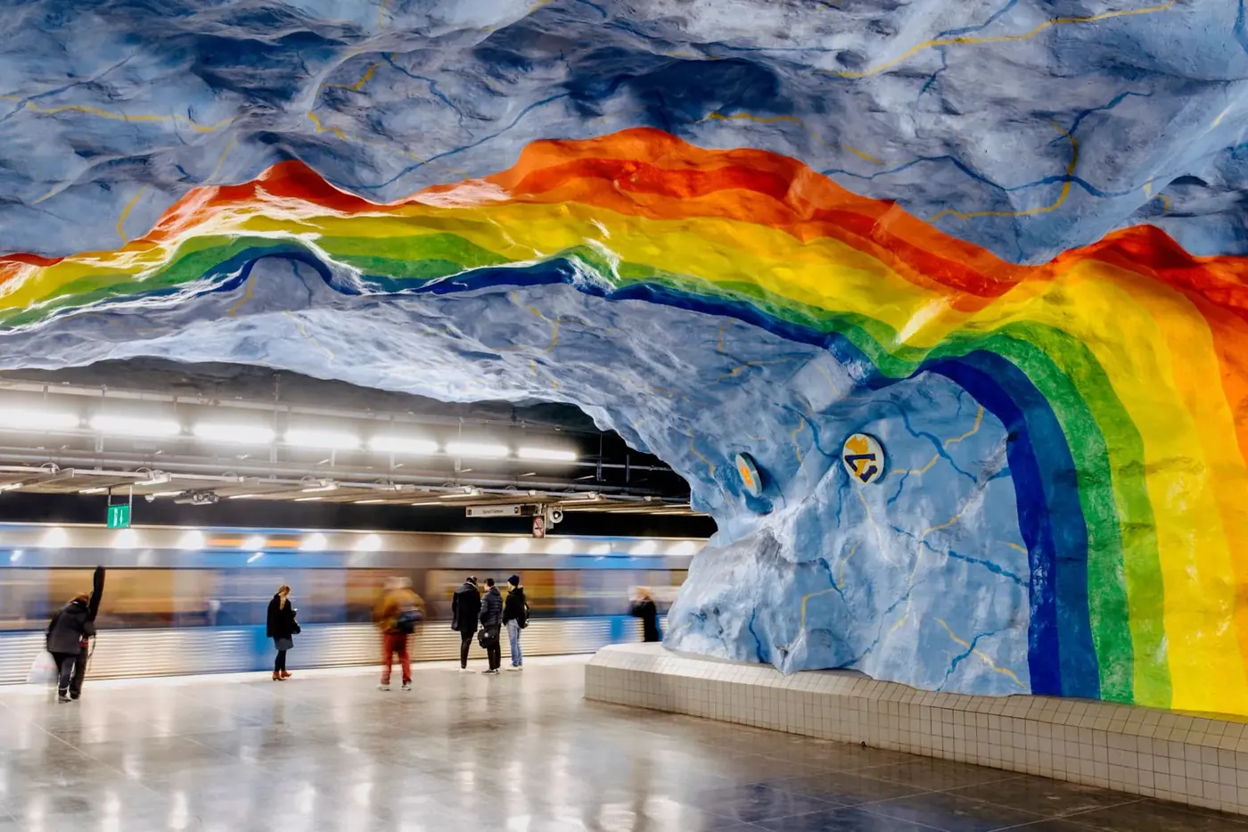 A rainbow painted across the rock ceiling of a Stockholm metro station