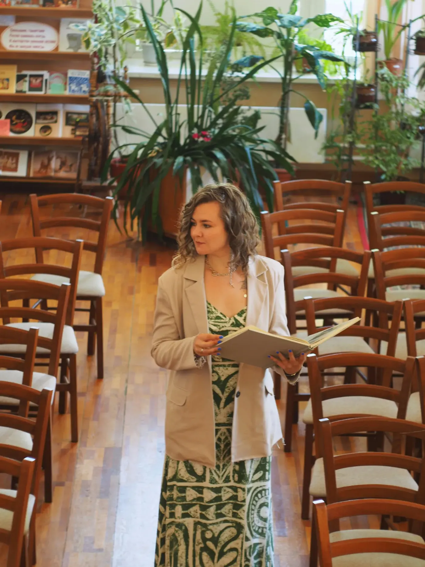 A facilitator holding an open book in a room set out for a seminar