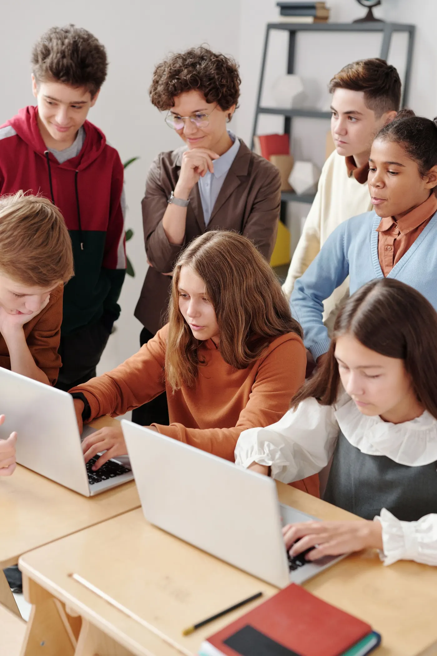 Students collaborating around a laptop in class